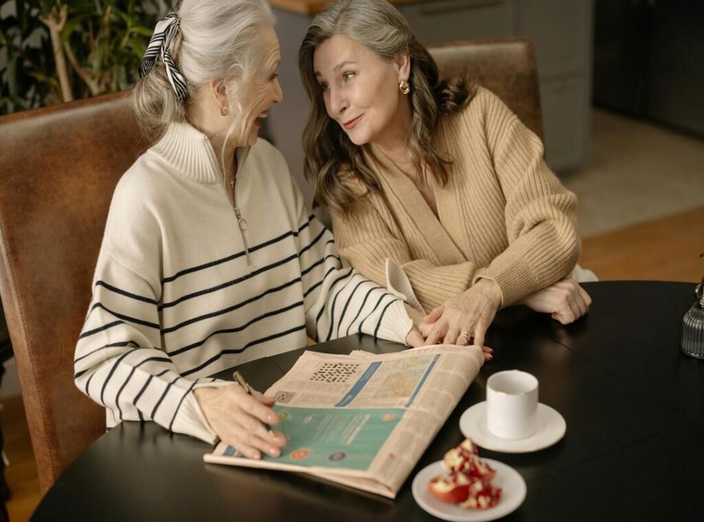 Conversation Around the “bumped things nyt crossword” Puzzle Clue Two elderly women discussing bumped things nyt crossword clue over coffee and a newspaper