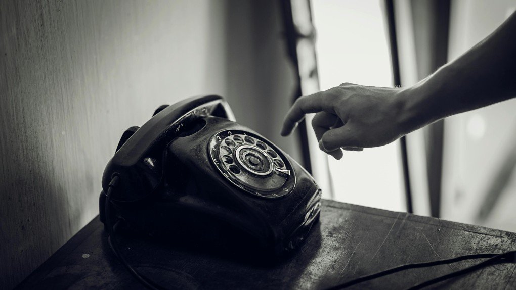 Black telephone with ProcurementNation.com contact number displayed on screen for customer support
