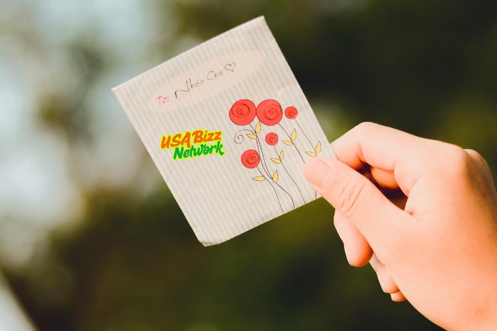 Hand holding a cute illustrated card with red flowers and handwritten message – artofzi creative touch