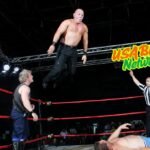 Wrestler performing an aerial move during a match, streaming on watchwrestling.ae for fans of live wrestling.