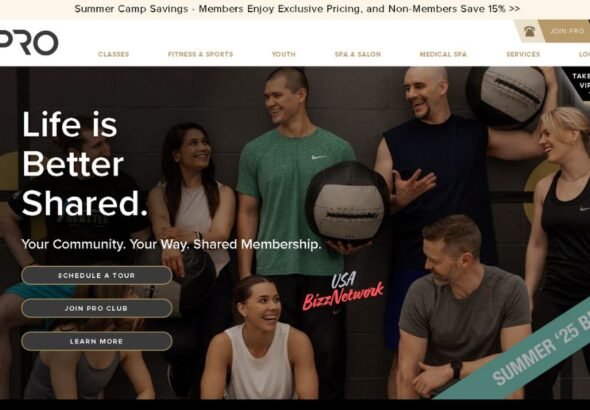 Group of smiling adults at Pro Club Seattle holding fitness equipment during a shared workout session